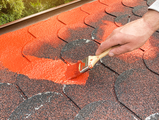 Applying waterproofing paint on roof shingles for leak prevention